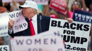 Republican presidential candidate Donald Trump kisses a "Women for Trump" sign during a campaign rally, Wednesday, Oct. 12, 2016, in Lakeland, Fla. (AP Photo/ Evan Vucci)